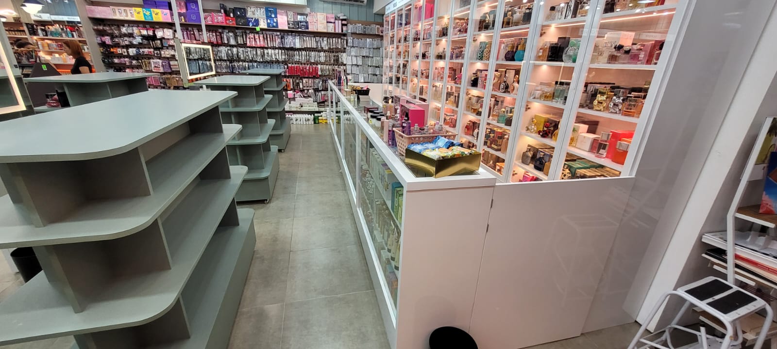 Loja de perfumaria com prateleiras e vitrines de vidro