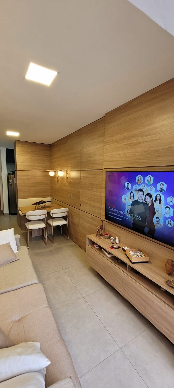 Sala de estar com painel de TV e parede de pedra